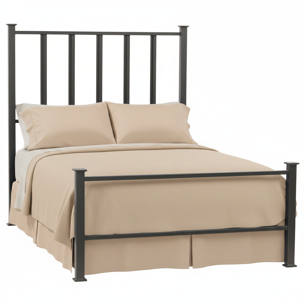 A natural black wrought iron bed frame with vertical spindles, shown with a beige mattress and pillows on it.