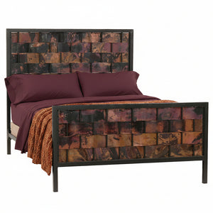 A full view of a double-sized iron bed with a copperweave design, featuring a headboard and footboard with hand-applied copper panels, in a room setting with bedding.