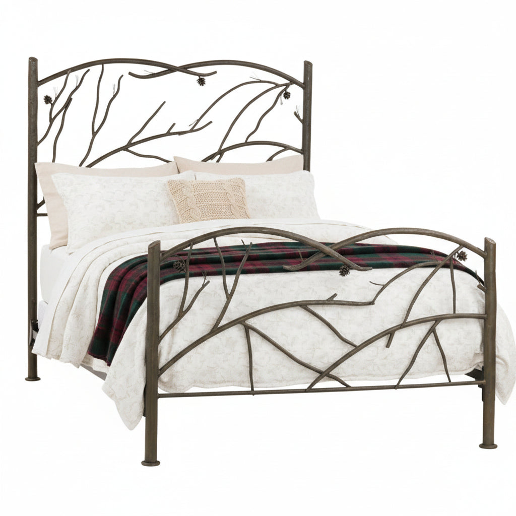 A wrought iron bed frame with a design that includes flowing branch motifs and pinecone accents, with a beige bedsheet on it.