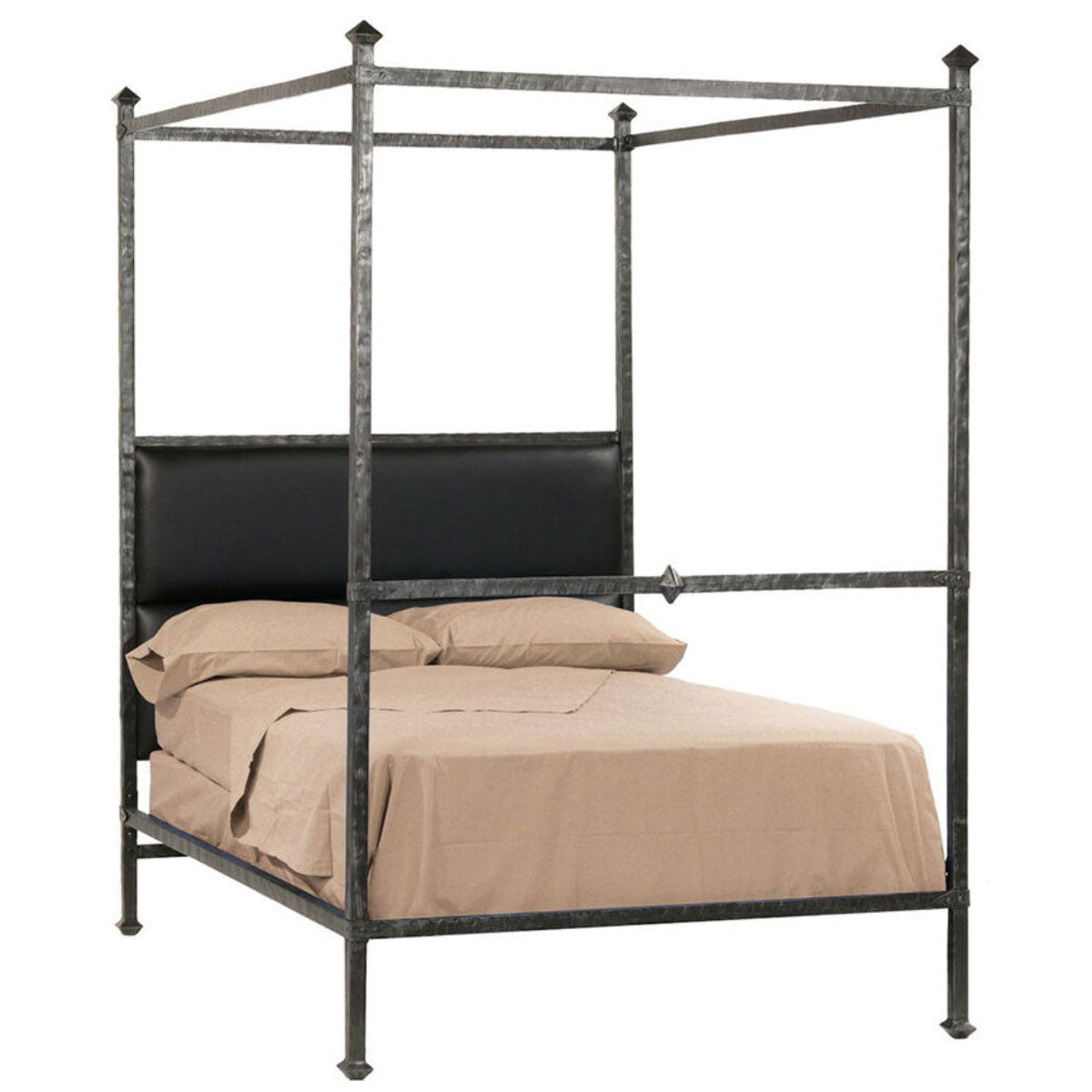 A four-poster canopy bed with a dark metal frame and upholstered headboard, styled with cream bedding in a bright, classic bedroom.