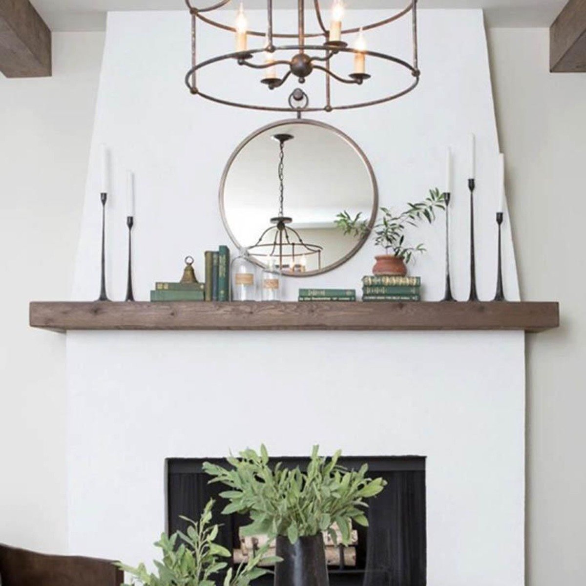 Black cast iron candlesticks styled on a white fireplace mantel