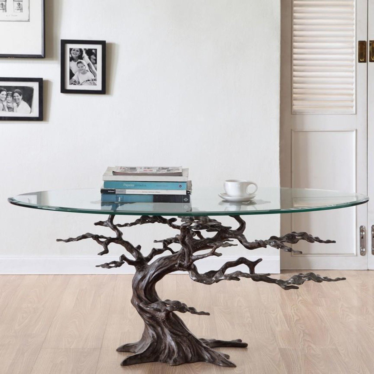 Sculptural cypress tree coffee table with an oval glass top in a bright living room